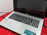 an open laptop computer sitting on top of a red sheet
