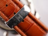 a close up of a watch with a leather strap