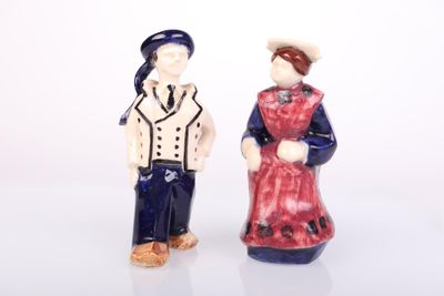 two figurines of a man and a woman standing next to each other