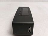 the back of a black device sitting on a white surface