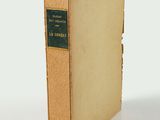 an old book sitting on top of a table next to a white wall