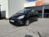 une voiture noire garée devant un bâtiment dans un parking