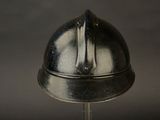 a metal helmet on a metal stand against a black background