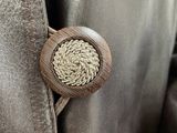 the back of a brown leather jacket with a button on it