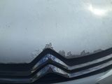 a close up of a car ' s front grill with snow on it