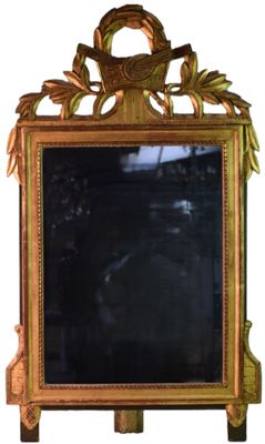 un miroir posé sur un pied, orné d'un oiseau