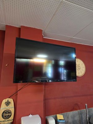 une télévision à écran plat fixée au mur au-dessus d'un canapé