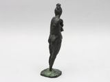a bronze statue of a woman standing on a green base