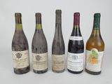 six bottles of wine are lined up in a row on a white surface