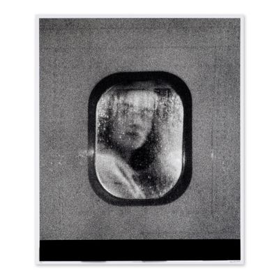 une photo en noir et blanc d'une femme regardant par la fenêtre