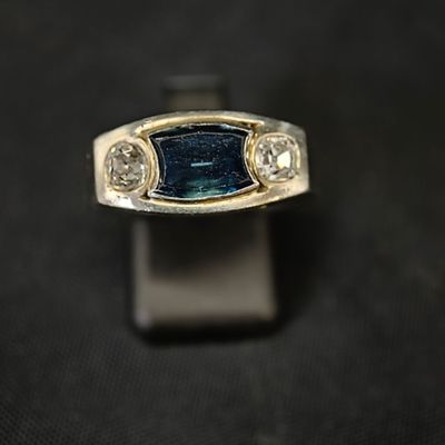 une image représentant une bague sertie d'une pierre bleue et de trois diamants