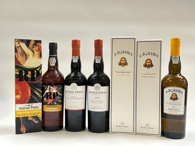 quatre bouteilles de vin sont alignées les unes à côté des autres près d'une boîte