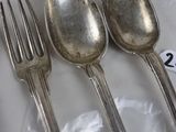 four spoons and two forks on a table