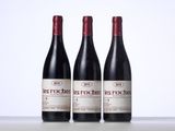 three bottles of red wine sitting on top of a table