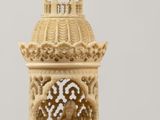 a small ivory figurine of a church with a cross on top of it
