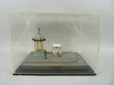 une petite maquette d'un petit bâtiment exposée dans une vitrine