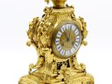 une horloge en or posée sur une surface blanche