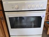 oven in a kitchen with wooden cabinets and tile flooring