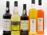plusieurs bouteilles d'alcool sont alignées sur une surface blanche