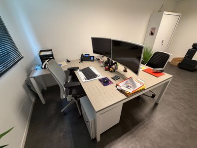 un bureau sur lequel se trouvent un ordinateur et deux écrans
