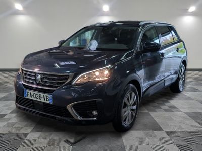 la voiture noire est garée sur un sol en damier dans le garage