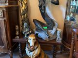 une statue représentant un chien assis à côté d'une statue représentant une femme