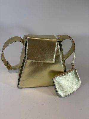silver and gold handbag and wallet on a white surface