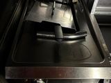 une plaque de cuisson noire sur laquelle se trouve un brûleur en métal