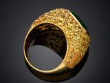 a close up of a gold ring with a green stone