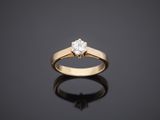 a single stone diamond ring on a black surface