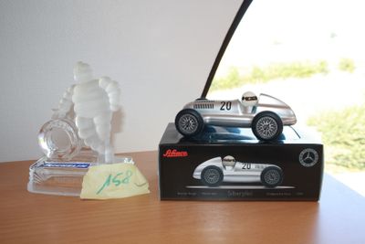 a toy car sitting on top of a table next to a glass figurine