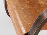 the back of a wooden chair with a metal frame and wood seat