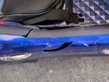 a blue car with a black seat and a black bag