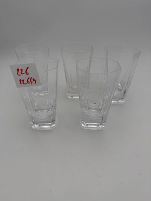 quatre verres à shot posés sur une table, avec une étiquette de prix dessus