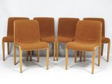six chaises orange sont alignées devant un fond blanc