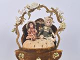 a figurine of a woman and two children in a basket