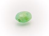 a close up of a green stone on a white surface