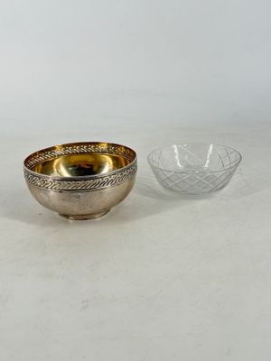 two silver and gold bowls on a white surface