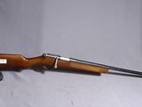 un vieux fusil avec un canon en bois et une poignée en métal