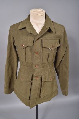 une veste verte posée sur un mannequin, sur un fond gris