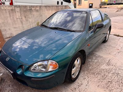 une voiture verte garée sur un parking à côté d'un immeuble