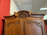a wooden armoire in a room with a red wall
