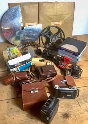 beaucoup de vieux appareils photo et d'autres objets sur la table