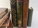 several old books are stacked on top of each other on a table