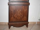 a grandfather clock sitting on top of a wooden cabinet