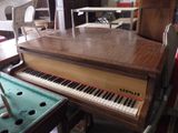 a piano that is sitting in a room with a pool table