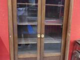 une armoire en bois avec une porte vitrée et une étagère