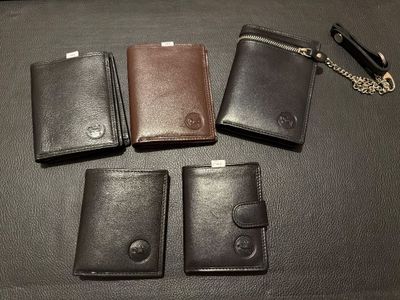 three leather wallets and a keychain sitting on a table