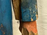 a wooden statue of a man with a blue jacket on