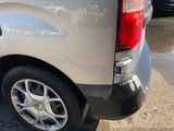 a silver van parked in a parking lot next to other cars